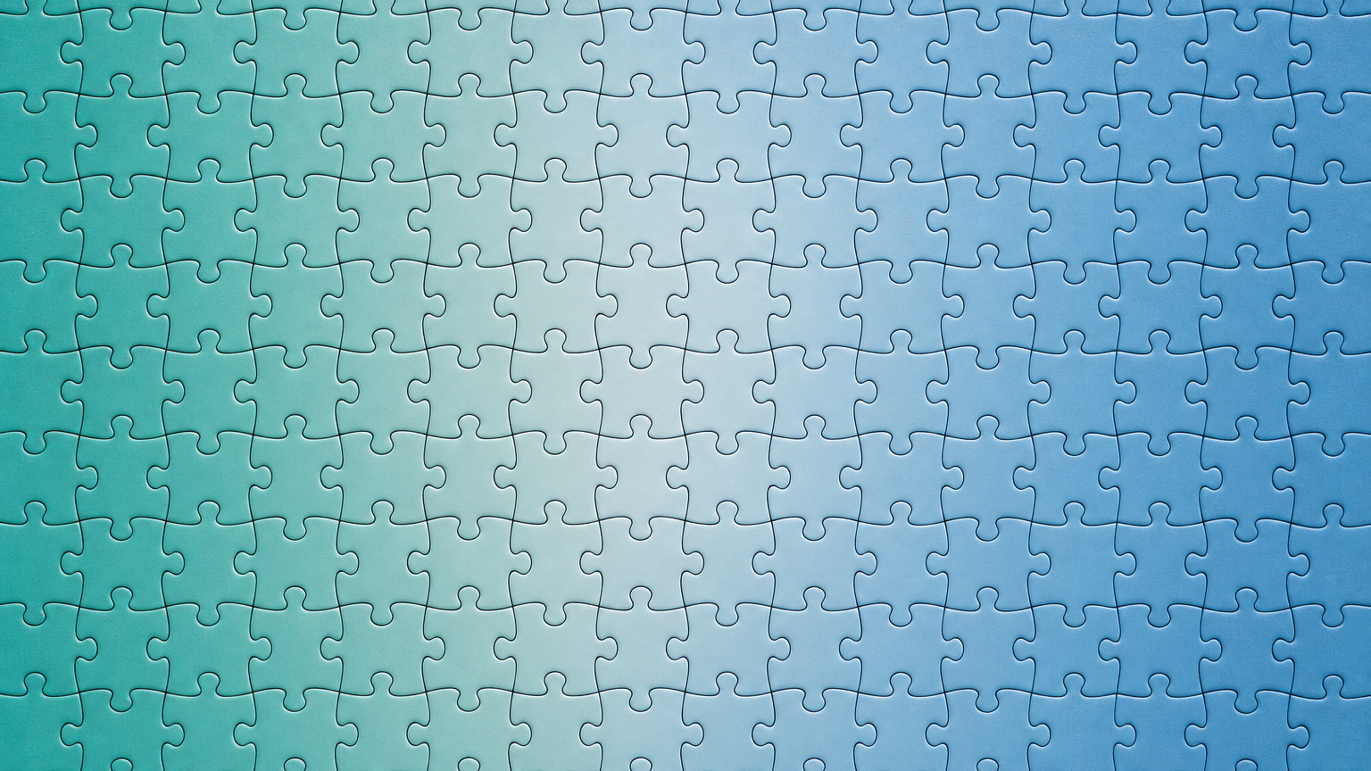 Overhead photo of many interlocking puzzle pieces in two complementary colors forming a seamless repeating pattern, suggesting integration and unified signal.