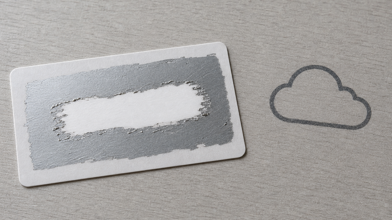 A top-down photo of a generic scratch-off code card and a plain cloud icon stamp on a neutral surface, suggesting covert code-based logins without showing readable text.